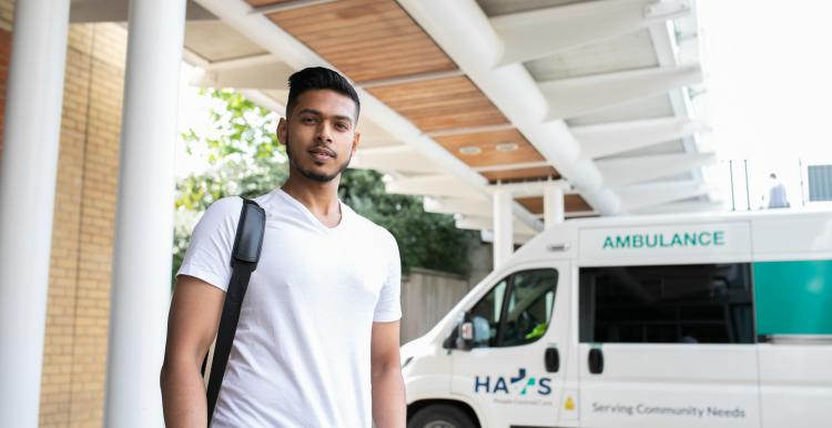 A young black man standing in front of an ambulance