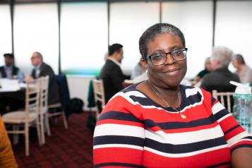 woman sitting in a room full of tables and chairs