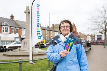 A Healthwatch volunteer holding a leaflet